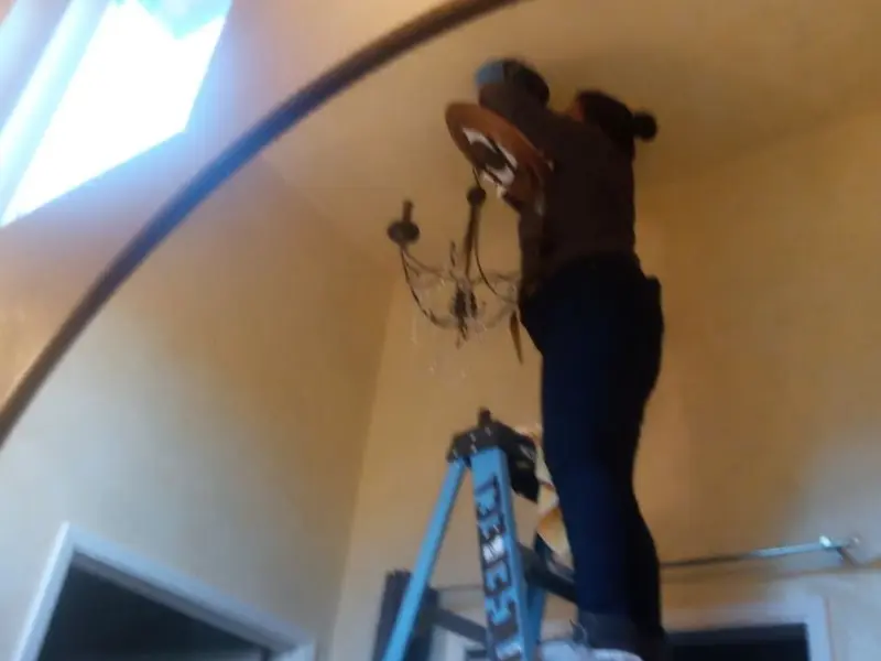 Electrician installing a chandelier in a East Petersburg residence
